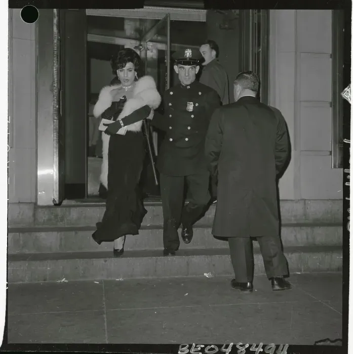 Framed Print : Policeman Leading a Man in Drag by the Arm Framed Print : Policeman Leading a Man in Drag by the Arm