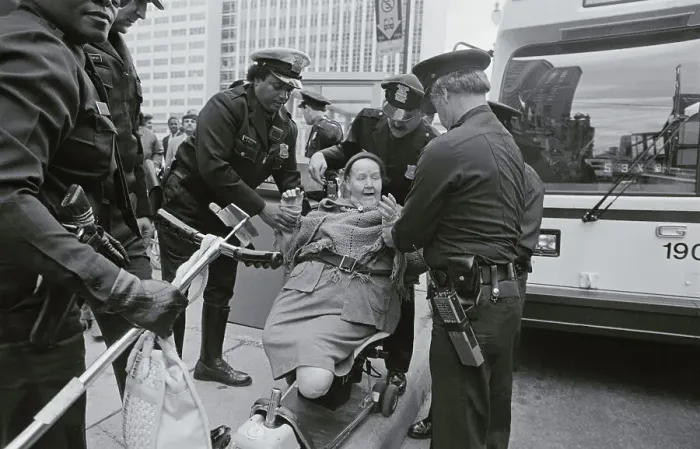 Framed Print : Policemen Arresting Disabled Woman Framed Print : Policemen Arresting Disabled Woman