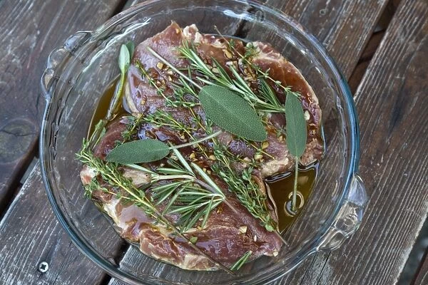 Pork neck steaks in marinade with herbs
