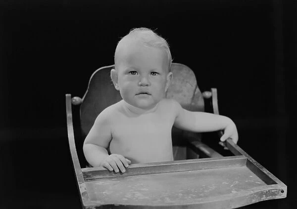 Portrait of baby boy (6-11 months) sitting in high chair