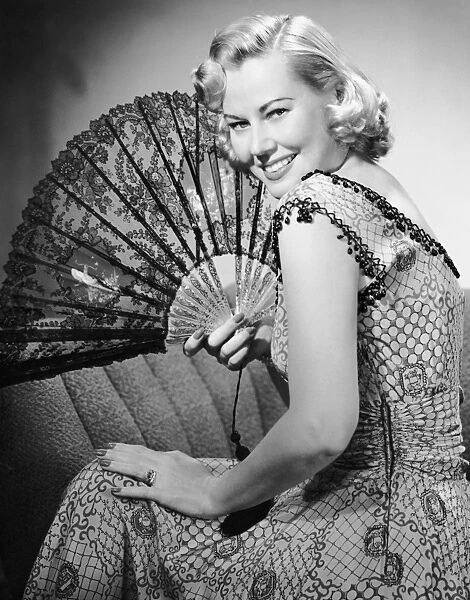 Portrait of blonde woman holding fan
