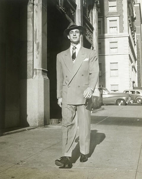 Portrait of man walking along city street