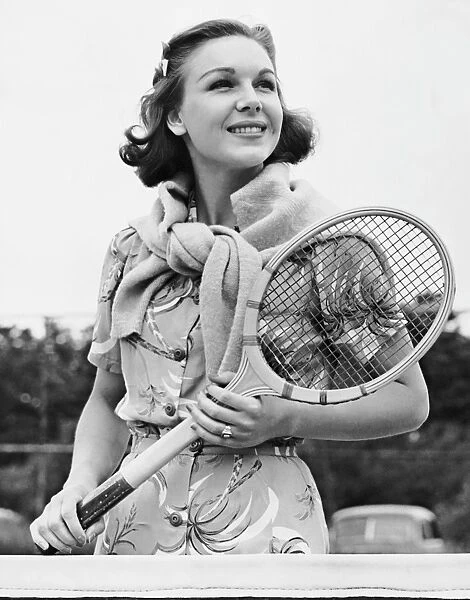 Portrait of woman with racquet on tennis court