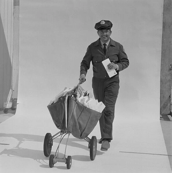 Postal worker carrying letters on wheel barrow against white background, portrait