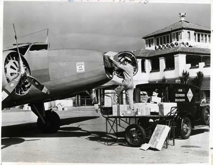 Framed Print : Postal Worker Loads Packages Into Plane Framed Print : Postal Worker Loads Packages Into Plane