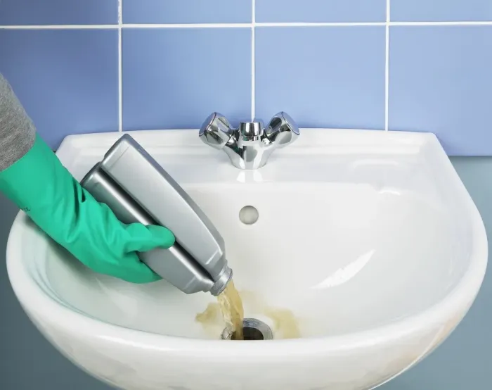 Framed Print : Pouring chemicals down a sink