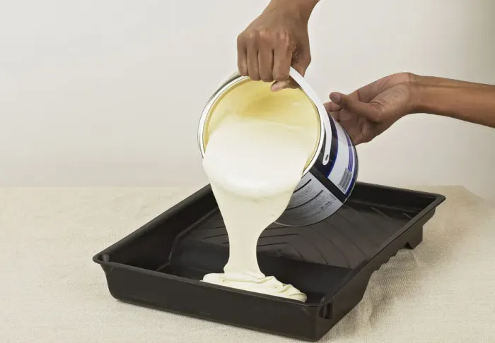 Framed Print : Pouring yellow paint in to a roller tray Framed Print : Pouring yellow paint in to a roller tray