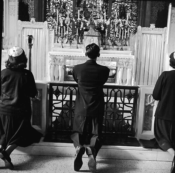 At Prayer. circa 1950: Visitors from the neighbourhood, as well as