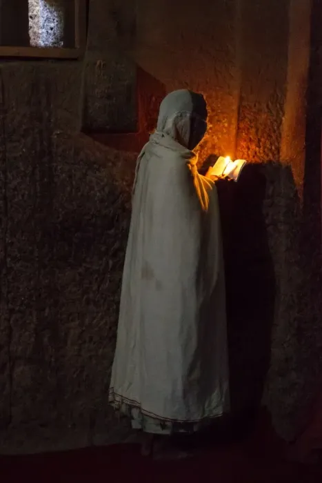 Framed Print : Prayers. A woman reads the bible under the light of a candle in Bet Medhane Framed Print : Prayers. A woman reads the bible under the light of a candle in Bet Medhane