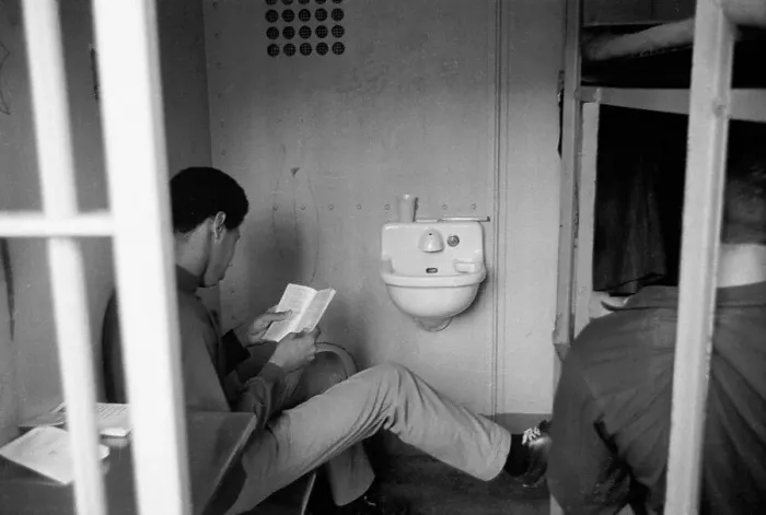 Framed Print : Prisoner Reading Book in Prison Cell Framed Print : Prisoner Reading Book in Prison Cell