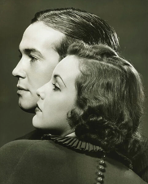 Profiles of couple posing in studio, (B&W), close-up, portrait