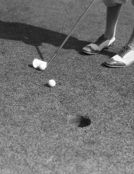 Putting Green With Feet In Golf Shoes In Upper Rig
