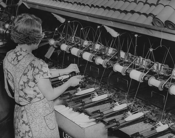 Quilling. A female worker quilling at a textile mill, USA, circa 1930
