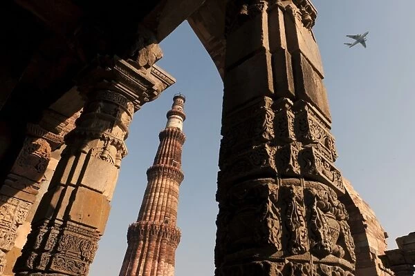 Qutb Minar minaret with aircraft flying above, UNESCO World Cultural Heritage, New Delhi, India