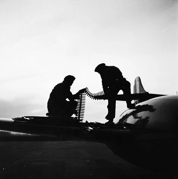 RAF Squad. 1955: Armourers of the No 264 Squadron arm the guns of a Meteor