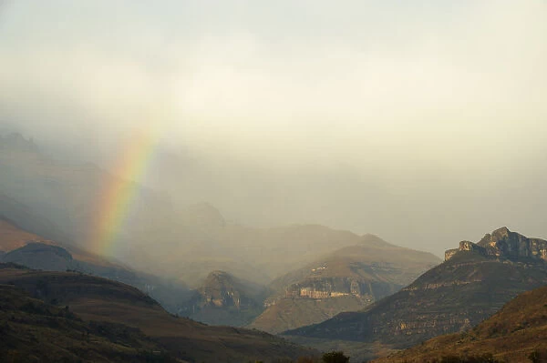 Rainbow at the base of the Amphitheatre range in the Drakensberg Mountains, Royal Natal, Kwazulu-Natal, South Africa