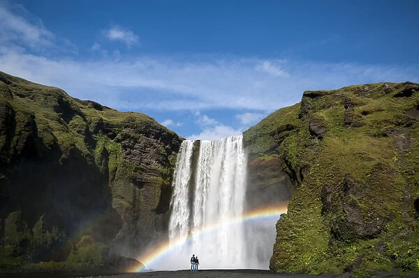 Rainbow, couple watching the Skogafoss waterfall on the Skoga river, ring road, Suourland, Sudurland, southern Iceland, Iceland, Europe