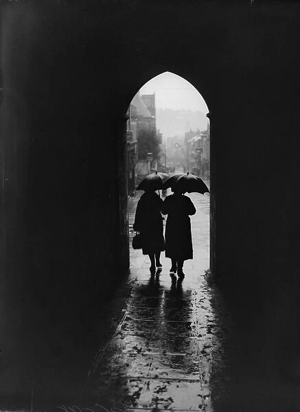Rainy Day. December 1934: Two women, holding raised umbrellas