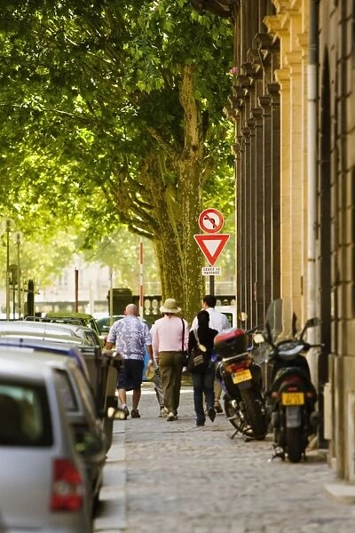 Rear view of five people walking on a sidewalk, Bordeaux, Aquitaine, France