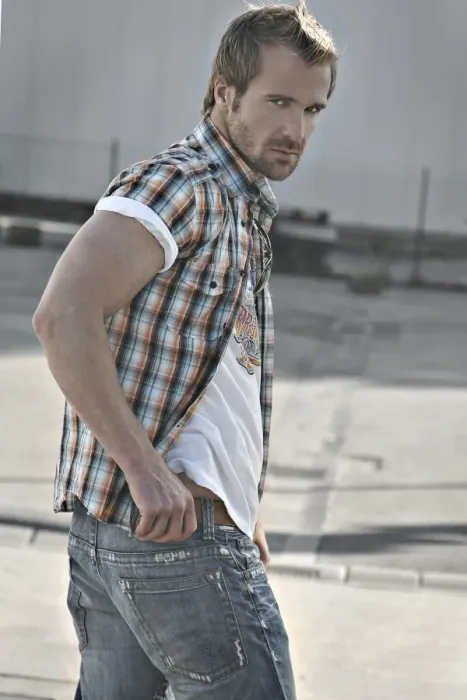 Framed Print : Rebellious man wearing jeans and a plaid shirt at a gas station, turning round Framed Print : Rebellious man wearing jeans and a plaid shirt at a gas station, turning round
