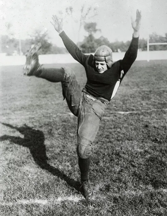 Framed Print : Red Grange Kicking Football