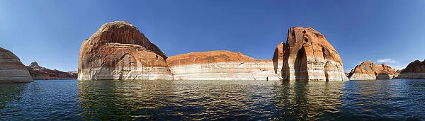Red Navajo sandstone cliffs, rock formations rising from the deep blue waters of Lake Powell, Page, Arizona, USA