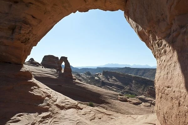 Red sandstone, Delicate Arch, a natural stone arch seen through the window of Frame Arch, Arches National Park, Utah, Western United States, United States of America, North America
