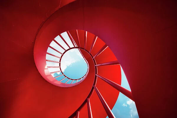 Red spiral staircase against sky