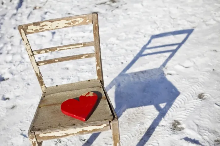 Framed Print : Red wooden heart placed on an old chair in snow Framed Print : Red wooden heart placed on an old chair in snow