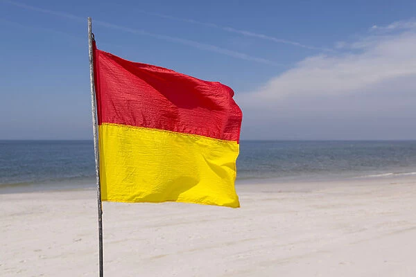 A red-yellow flag waves on the beach, near Kampen, Sylt, Schleswig-Holstein, Germany