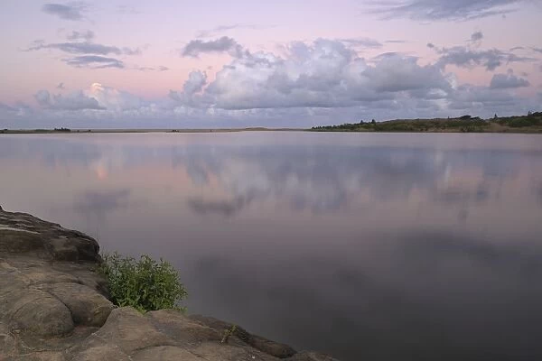 Reflected clouds in shoreline estuary system with embankment in foreground, St Lucia, Kwazulu-Natal, South Africa