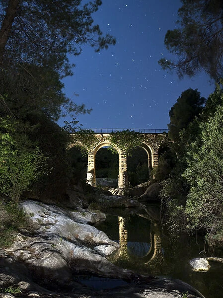 Reflection of a bridge on the water of a river in the night