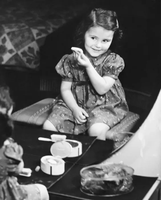 Framed Print : Reflection of girl (4-5) sitting in front of mirror, applying face powder (B&W), elevated view