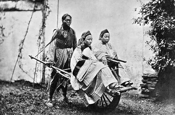 Rickshaw. circa 1890: A couple of women being pushed in a rickshaw