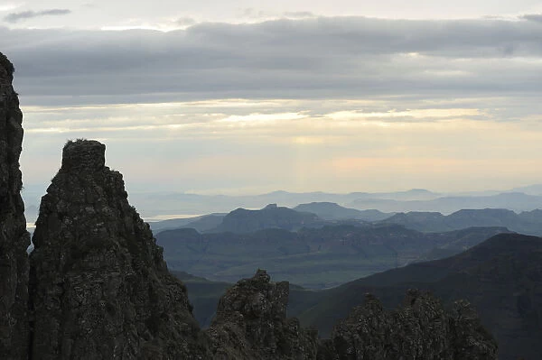 Ridge of rock framing mountains and clouds in the distance, Royal Natal, Drakensberg uKhahlamba National Park, Kwazulu-Natal, South Africa