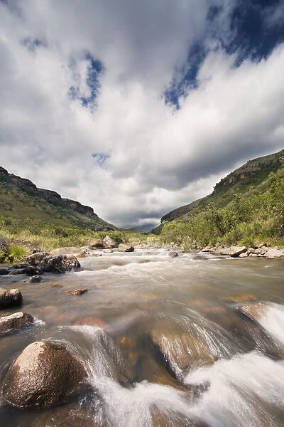 River landscape in Drakensberg with dramatic clouds and mountain