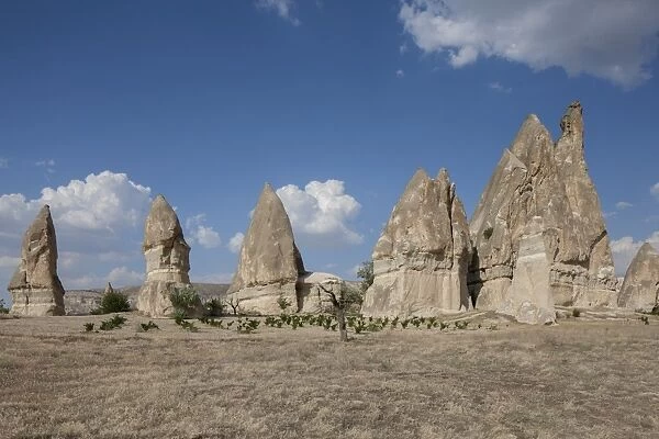 Rock formations on arid landscape against blue sky