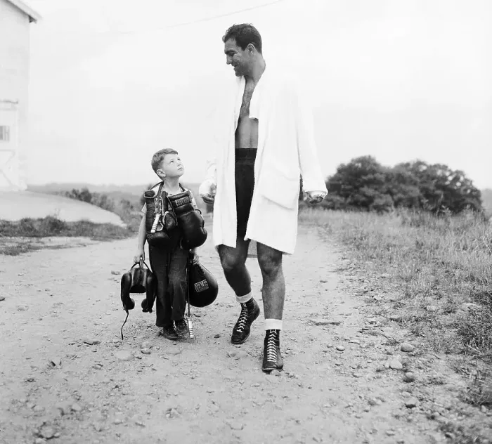 Framed Print : Rocky Marciano with Boy Carrying His Gear Framed Print : Rocky Marciano with Boy Carrying His Gear