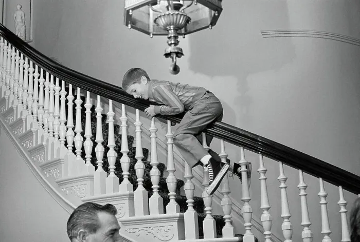 Framed Print : Ronald Reagan, Jr. Sliding Down Stair Banister