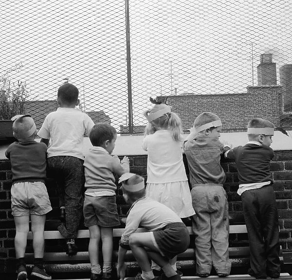 Roof View. Children looking out from the rooftop playground of the Jones