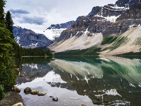 Rugged Canadian Rocky Mountains and glaciers reflected in a tranquil lake