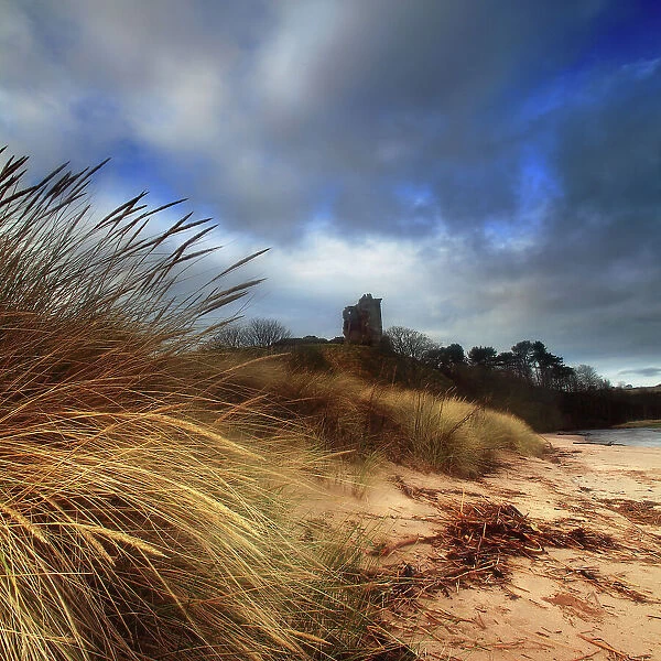 Ruined castle in sand dunes shore