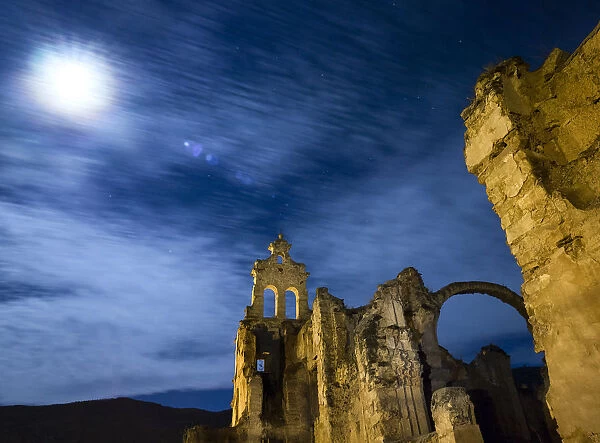 Ruins of abandoned convent one night with blue sky and the full moon