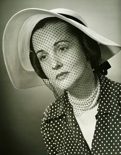 Sad woman in hat with veil posing in studio, (B&W), (Close-up), (Portrait)