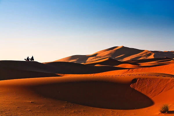Sahara VIews. pair of travelers enjoying spectacular view over Sahara as golden light