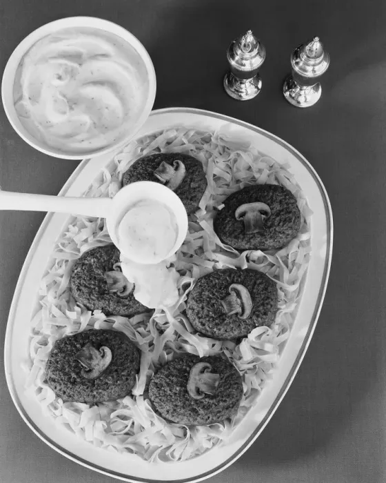 Framed Print : Savoury sauce being poured on cutlet with pasta, close-up Framed Print : Savoury sauce being poured on cutlet with pasta, close-up