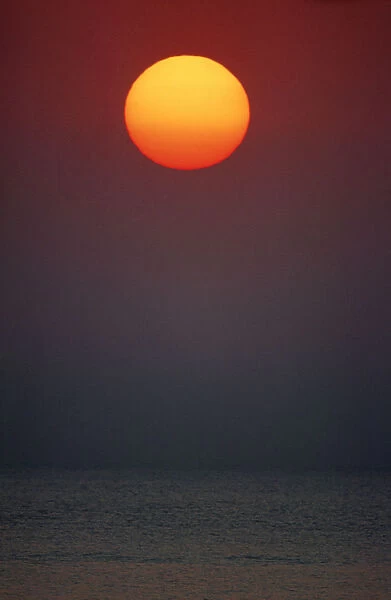 Scenic Portrait of the Sun Setting Over the Ocean