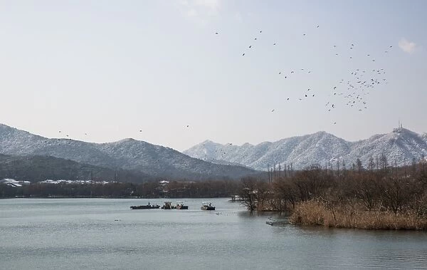 Scenic View Of the West Lake surrounded by snow-covered hills, Hangzhou, China