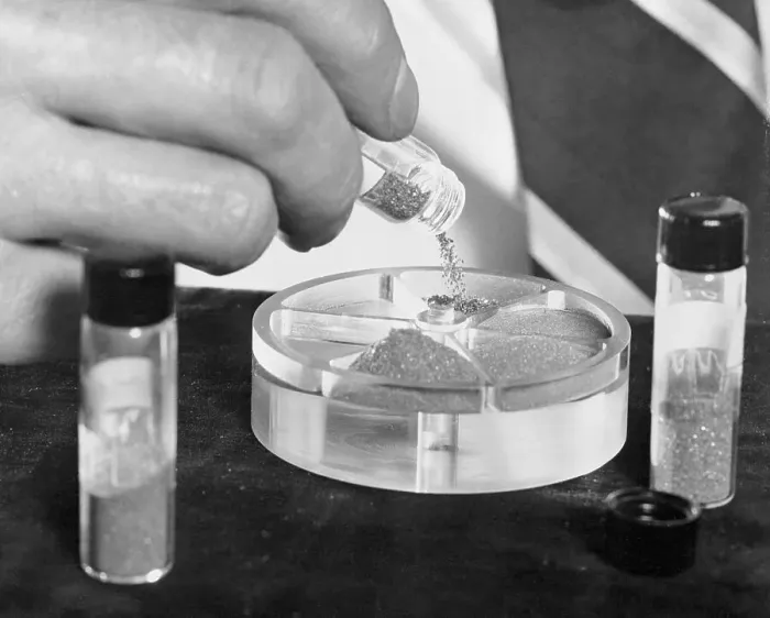 Framed Print : Scientist Pouring Manmade Diamonds into a Container Framed Print : Scientist Pouring Manmade Diamonds into a Container