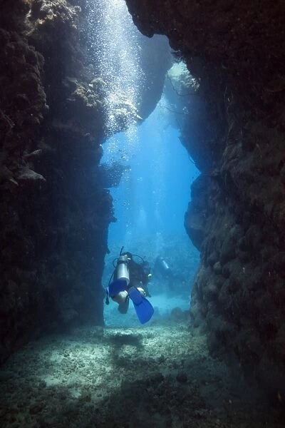 Scuba diver leaving a cave, Marsa Alam, Red Sea, Egypt, Africa